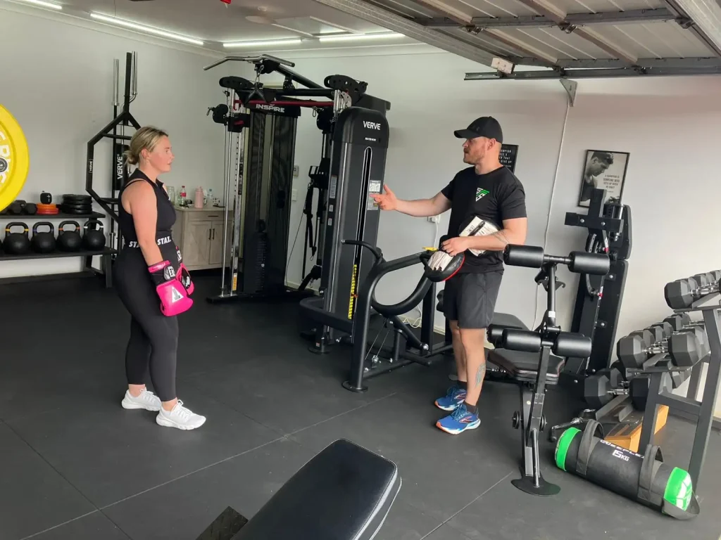 Trainer talking with client wearing boxing gloves