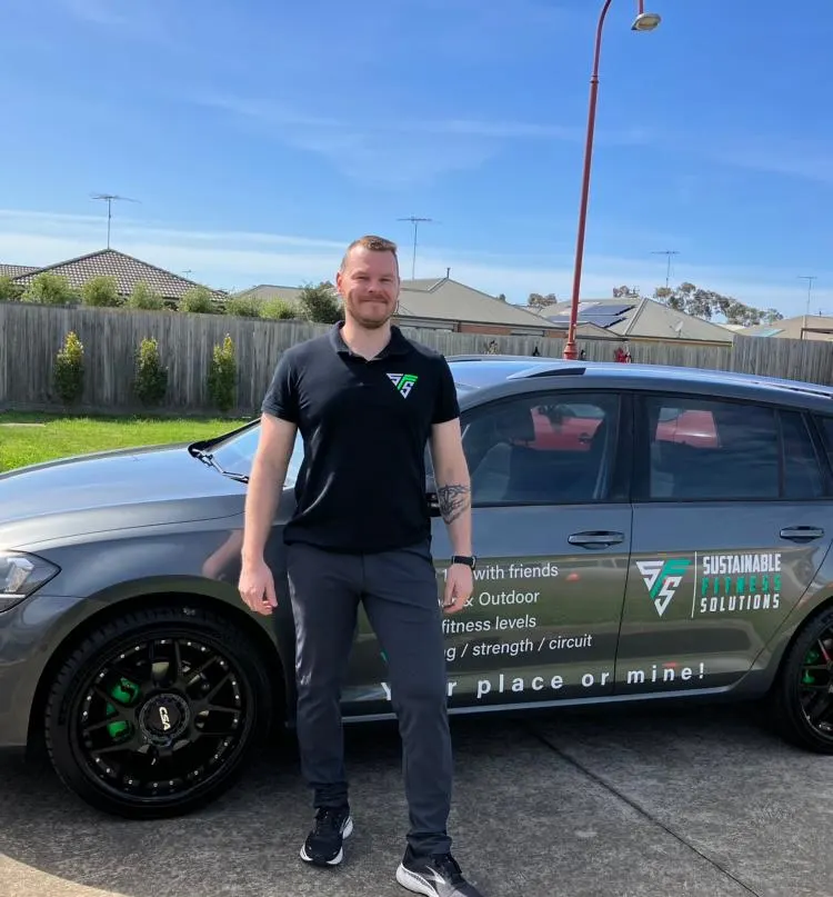 Owner, Mark, smiling at camera standing in front of car