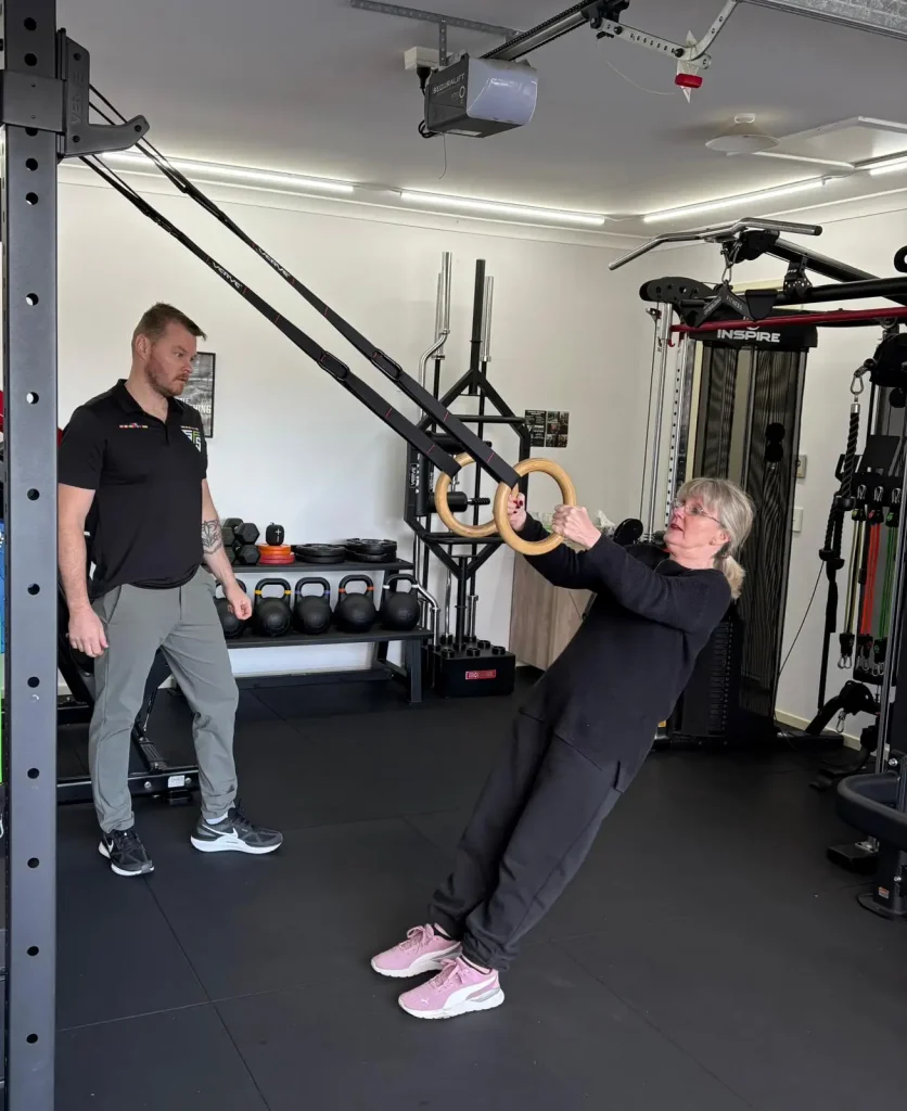 Middle aged woman training with personal traine